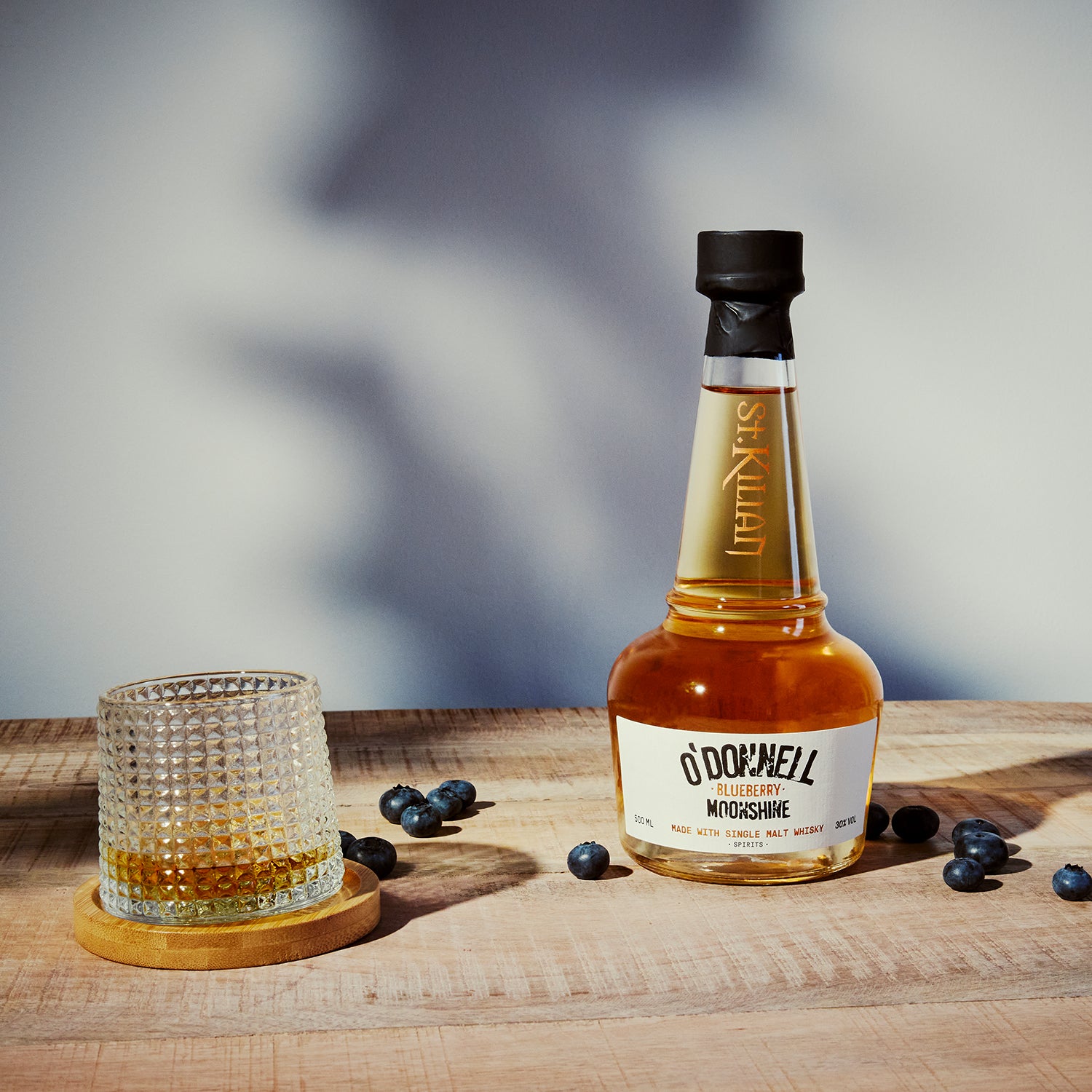 O'Donnell Blueberry Moonshine, O'Donnell en St.Kilian, hergestellt mit Single Malt Whisky naast een tumblerglas
