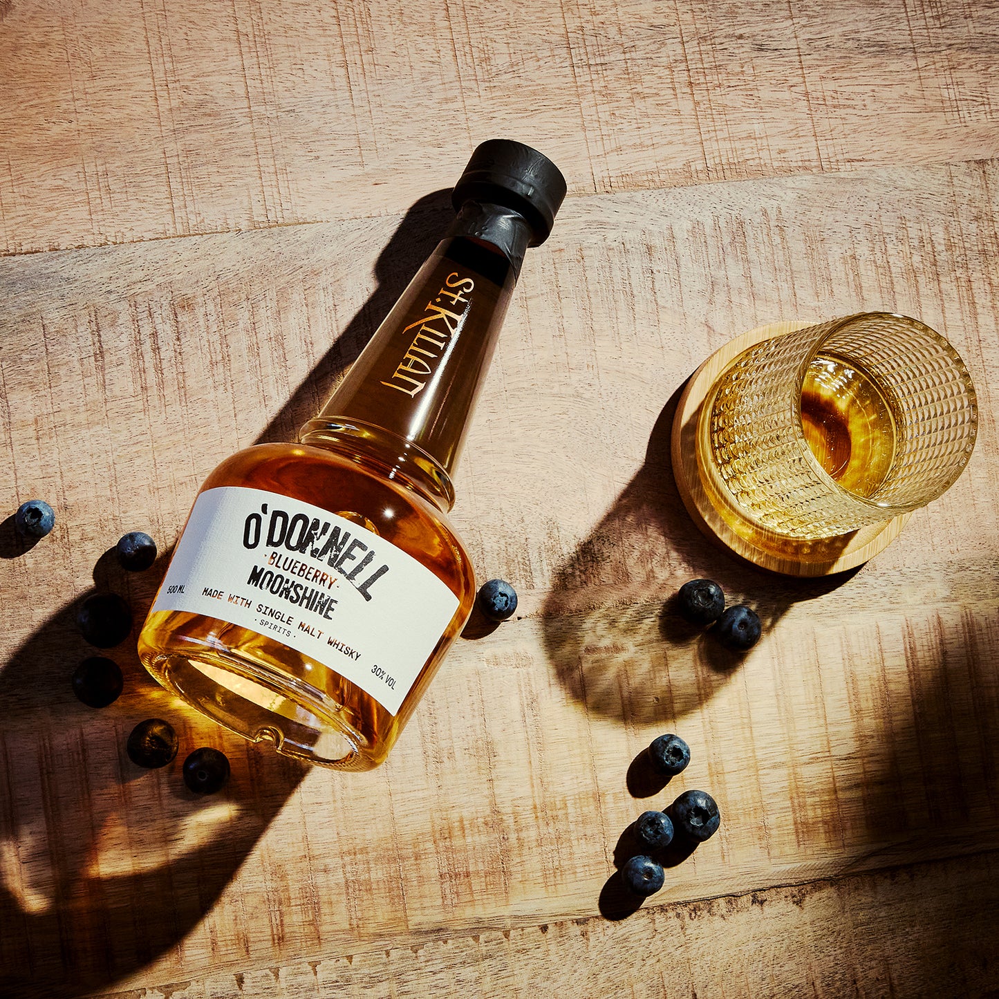 O'Donnell Blueberry Moonshine, O'Donnell en St.Kilian, hergestellt mit Single Malt Whisky naast een tumblerglas
