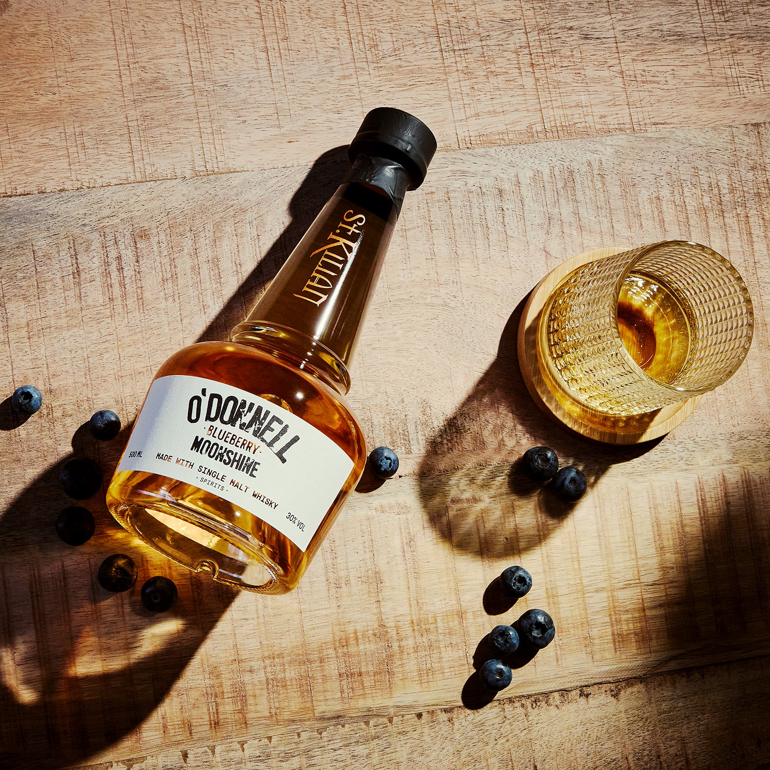 O'Donnell Blueberry Moonshine, O'Donnell en St.Kilian, hergestellt mit Single Malt Whisky naast een tumblerglas
