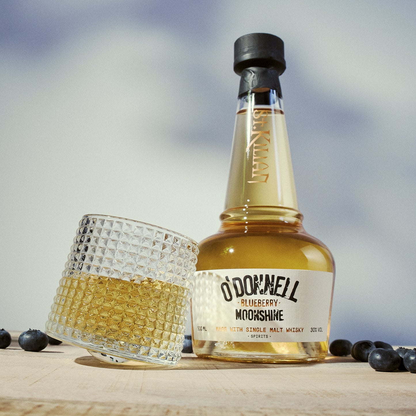 O'Donnell Blueberry Moonshine, O'Donnell en St.Kilian, hergestellt mit Single Malt Whisky naast een tumblerglas
