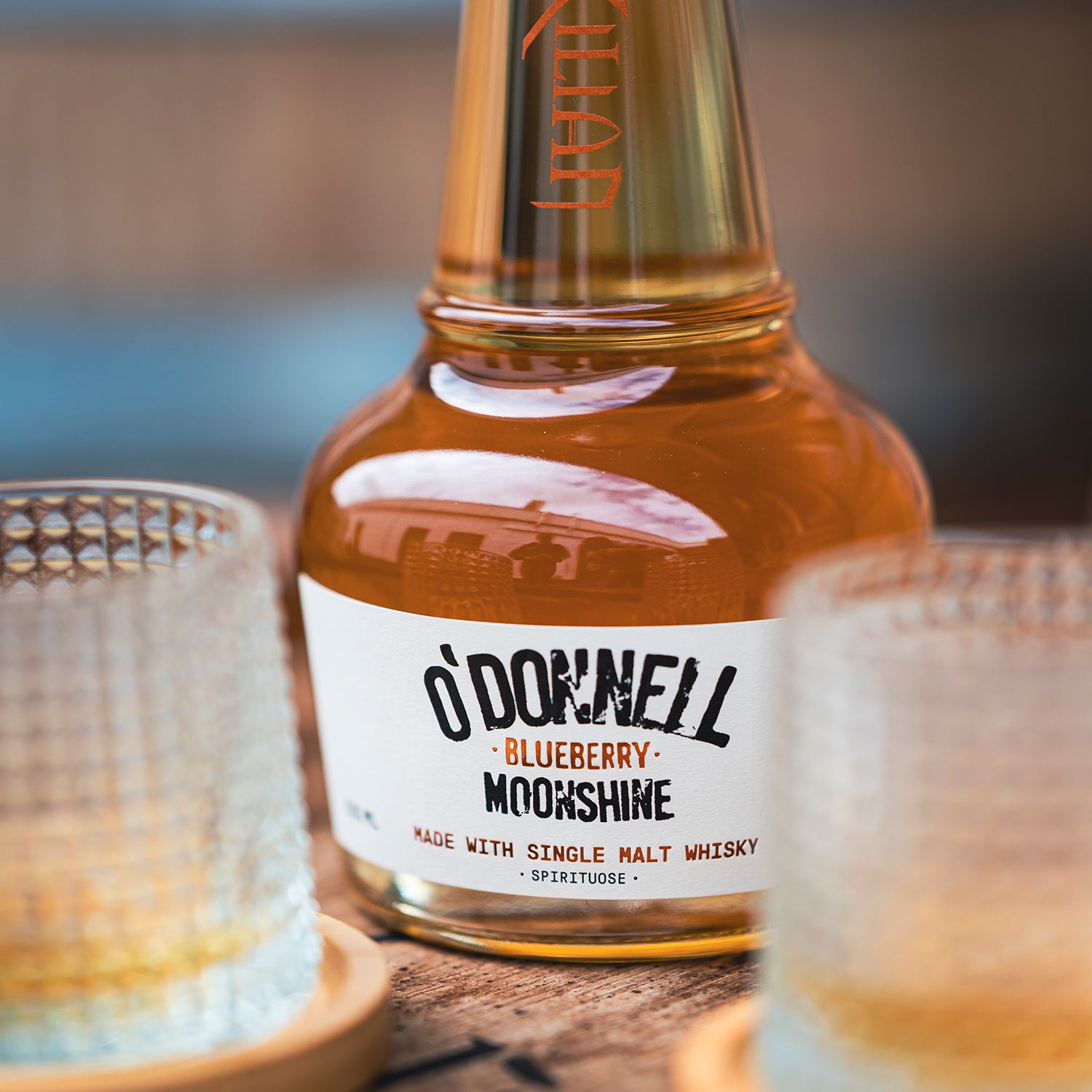 O'Donnell Blueberry Moonshine, O'Donnell en St.Kilian, hergestellt mit Single Malt Whisky naast een tumblerglas
