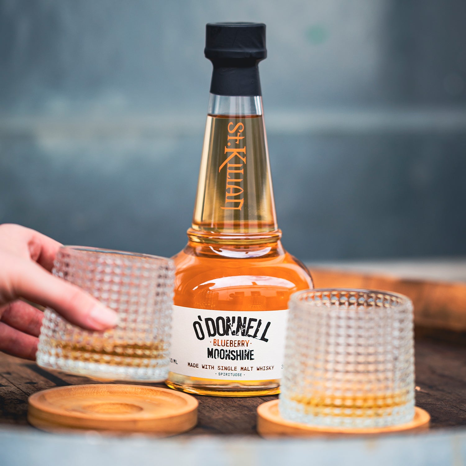 O'Donnell Blueberry Moonshine, O'Donnell en St.Kilian, hergestellt mit Single Malt Whisky naast een tumblerglas
