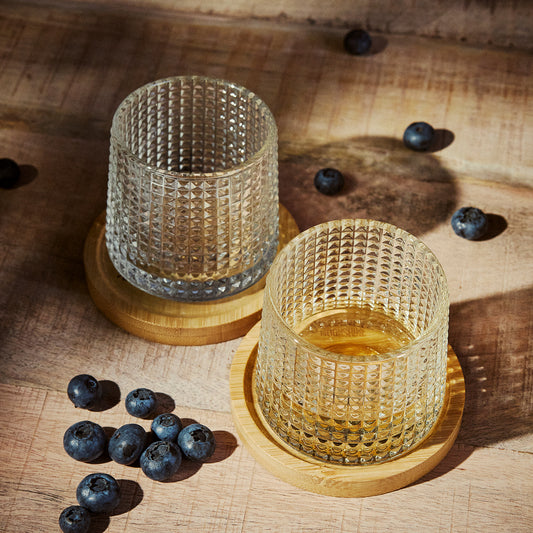 Twee bekerglazen omringd door bosbessen.
