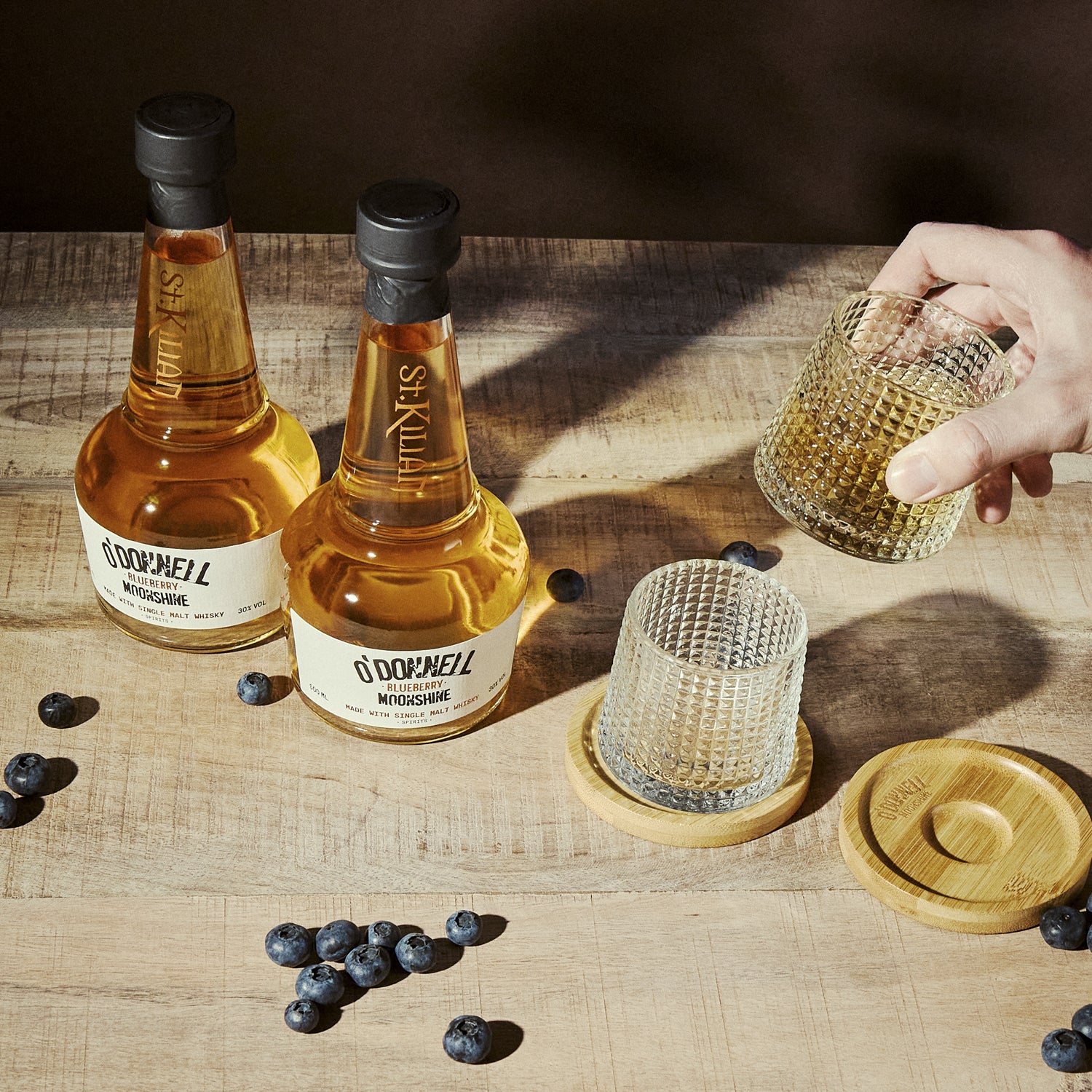 O'Donnell Blueberry Moonshine, O'Donnell en St.Kilian, hergestellt mit Single Malt Whisky naast een tumblerglas
