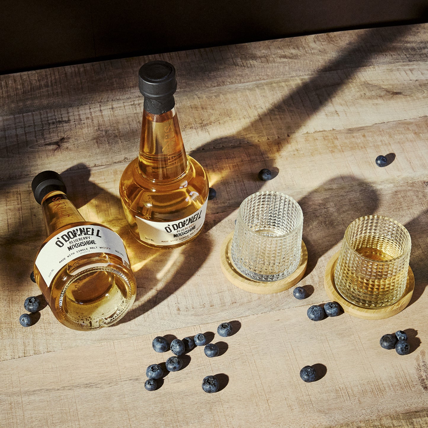 O'Donnell Blueberry Moonshine, O'Donnell en St.Kilian, hergestellt mit Single Malt Whisky naast een tumblerglas
