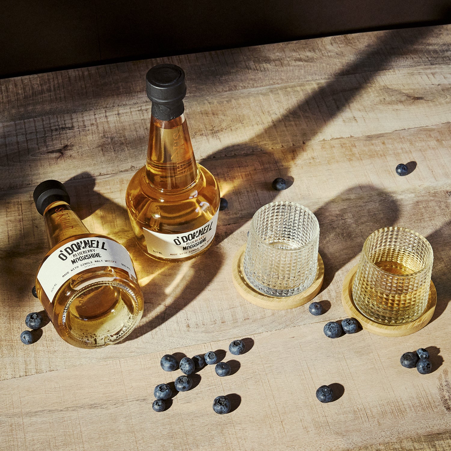 O'Donnell Blueberry Moonshine, O'Donnell en St.Kilian, hergestellt mit Single Malt Whisky naast een tumblerglas
