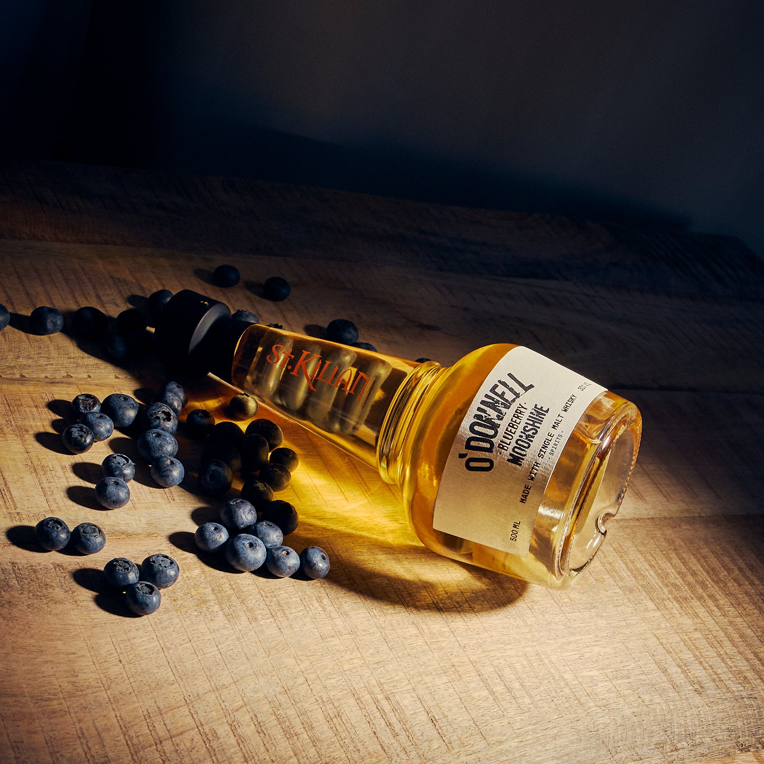 Een O'Donnell bosbessen moonshine x whisky gelegd op een tafel met bosbessen
