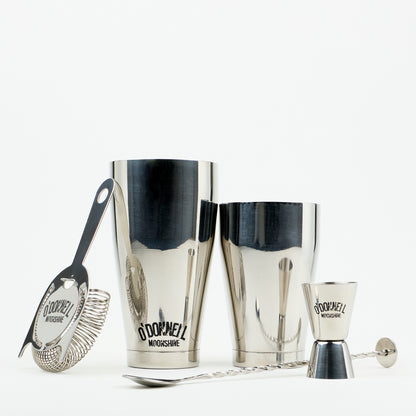 O'Donnell Moonshine-bar-set van roestvrij staal met Boston Shaker, barzeef, jigger en barllepel tegen een witte achtergrond.