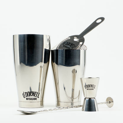 O'Donnell Moonshine-bar-set van roestvrij staal met Boston Shaker, barzeef, jigger en barllepel tegen een witte achtergrond.